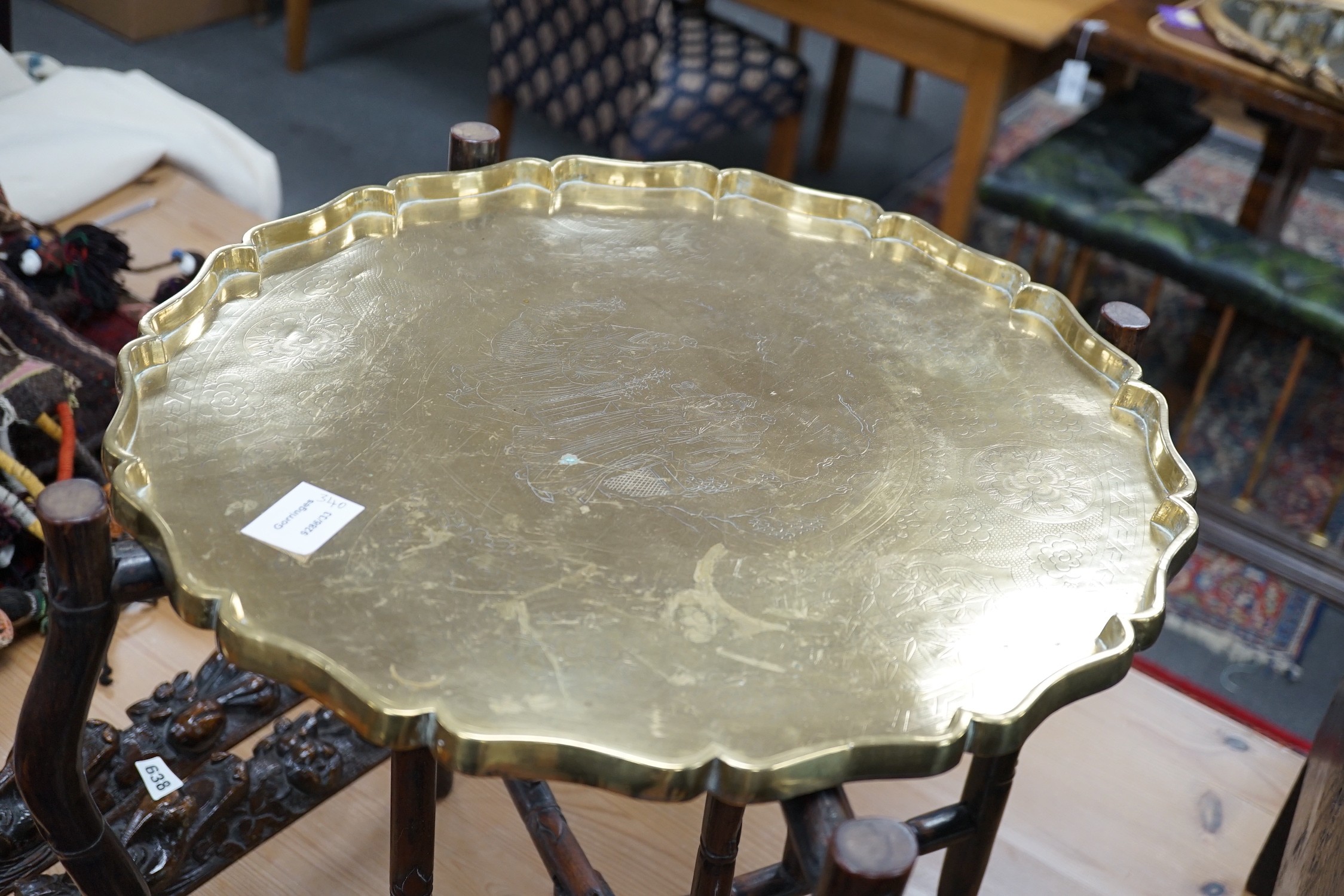 A Chinese brass tray topped hongmu folding occasional table, diameter 56cm *Please note the sale commences at 9am.